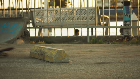 Skateboarder-jumping-over-concrete-block-in-Los-Angeles-coastline