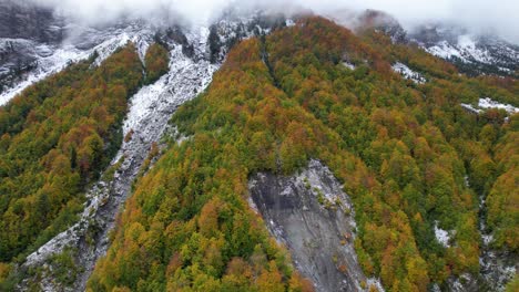 Die-Ersten-Wintertage-Auf-Den-Alpenbergen-Mit-Bunten-Wäldern-Und-Steinen,-Die-Mit-Weißem-Schnee-Und-Nebel-Bedeckt-Sind