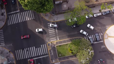 Ascend-Aerial-top-down-of-cars-driving-around-corner-in-city-of-Buenos-Aires-during-daytime---4K-Drone-shot