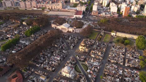 Aerial-shot-showing-Entrance-Of-Chacarita-Cemetery-with-Church-and-skyscraper-building-of-Buenos-Aires-Skyline-in-background