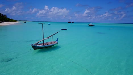 Traditional-Maldivian-Dhoni-sailboat,-pan-around-boat-in-clear-aqua-sea-4k