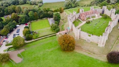 Aerial:-Framlingham-Castle-with-car-parking-lot-at-Suffolk,-England---drone-tracking-shot