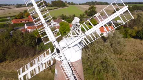 Billingford-Windmill-at-road-side-field-area-with-house-in-Diss,-Norfolk---aerial-drone-flying-shot