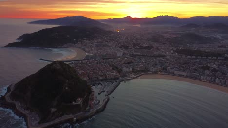 Luftaufnahme-Der-Stadt-San-Sebastián,-Sandstrand-Zum-Surfen-Und-Stadtbild-Während-Des-Farbenfrohen-Sonnenaufgangs