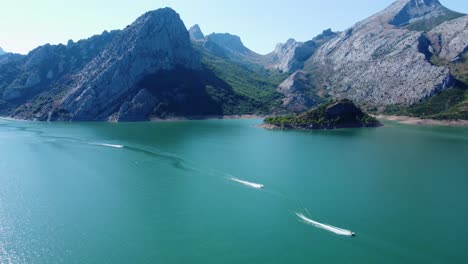 Captura-De-Drones-De-Pequeñas-Embarcaciones-En-Movimiento-En-El-Lago-Riaño-Y-El-Fondo-De-La-Cadena-Montañosa-En-España