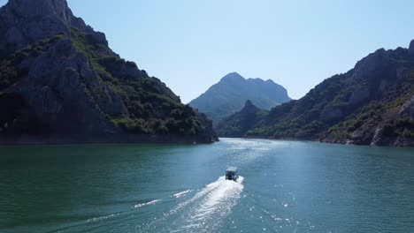 4K-drone-clip-following-a-river-boat-in-Riaño-lake-in-Castilla-y-Leon,-in-Spain