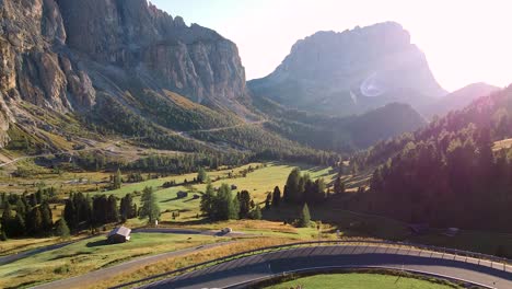 Breathtaking-mountain-landscape-with-valley,-road,-moving-cars-and-sunset-in-dolomites-mountains