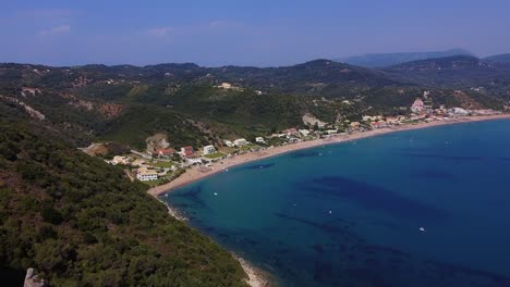 Drone-shot-of-corfu-bay,-long-stunning-beach,-hotels-and-small-swimming-boats