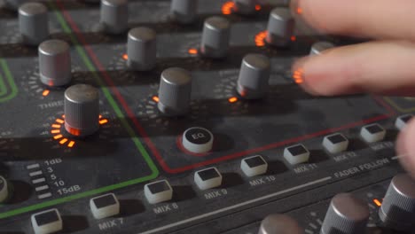 A-Person-Pressing-the-EQ-Button-on-a-Music-Mixer-Board