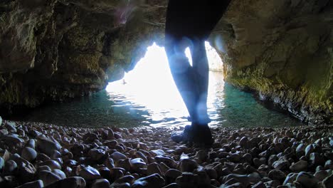 Vista-Dentro-De-La-Caverna-En-Kefalonia,-Grecia-Con-Un-Turista-Masculino-Caminando-Hacia-El-Mar