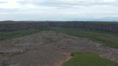 Eyjan-rock-island-at-horseshoe-shape-Asbyrgi-canyon-in-Iceland,-aerial