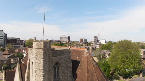 Ancient-stone-church-in-living-district-of-Kingston-upon-Thames,-aerial-fly-over-view
