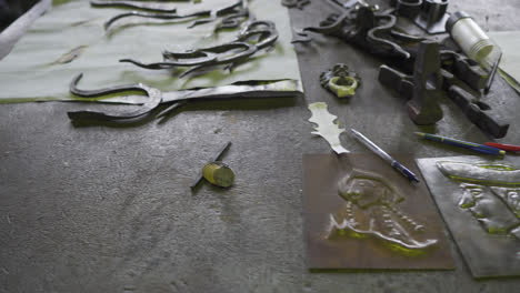 Embossed-Aluminum-Plates-With-Blacksmithing-Tools-On-Working-Table