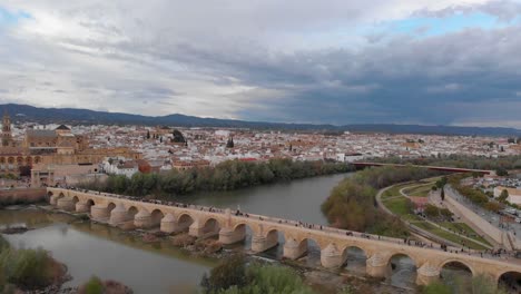 Cinematic-aerial-view-over-beautiful-Roman-bridge-and-Mezquita-in-Cordoba,-Spain
