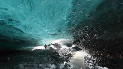 Static-shot-of-Person-walking-in-Ice-Cave-inside-dark-Glacier---Exploring-nature-of-Iceland,-Europe