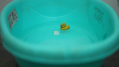 Babybadewanne-Mit-Wasser-Und-Gelber-Gummiente,-Die-Auf-Wasser-Schwimmt