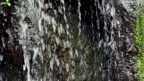 Schwenken-Des-Wasserfalls-Zwischen-Steinen-Mit-Moos