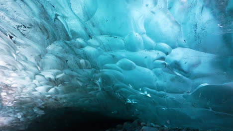 Toma-Panorámica-Glaciar-De-Cueva-De-Hielo-De-Color-Azul-Y-Sol-Iluminado-Detrás-De-La-Pared-Helada---Visitando-La-Naturaleza-De-Islandia
