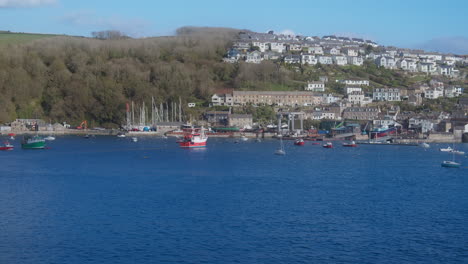 View-Across-from-Fowey-a-Fishing-Trawler-Boat-Enters-Polruan-Coastal-Village-Working-Harbour-Cornwall,-England---Wide-Shot