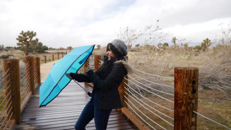 Eine-Hübsche-Hispanische-Frau,-Die-Einen-Kaputten-Regenschirm-In-Zeitlupe-öffnet-Und-Während-Eines-Regensturms-Bei-Schlechtem-Wetter-Lacht