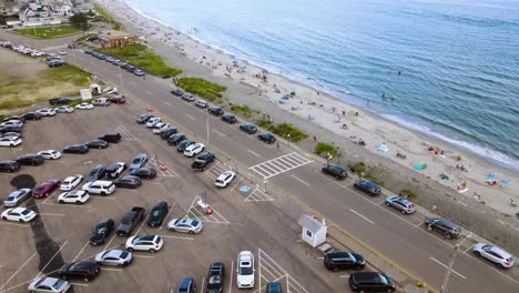 Busy-beachside-scene-during-weekends-showing-cars-parked-on-road-along-Nantasket-beach-Massachusetts,-USA