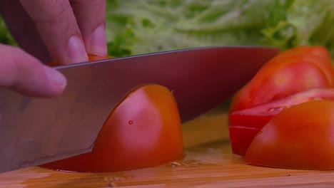 Schöne-Nahaufnahme-Eines-Professionellen-Kochs,-Der-Durch-Eine-Saftige-Tomate-Schneidet
