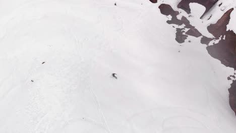 Aerial-view-of-someone-skiing-down-a-mountain
