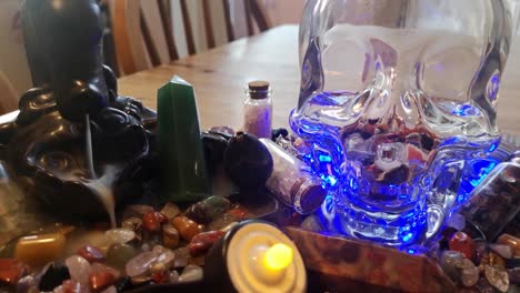 Collection-of-colourful-healing-crystals-and-mysterious-spiritual-skull-on-wooden-kitchen-table-with-burning-incense