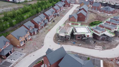 Modern-unfinished-British-scaffolding-framework-housing-construction-site-survey-project-aerial-view