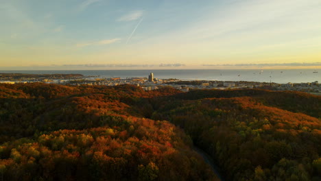 Warmer-Sonnenaufgang-über-Der-Stadt-Gdynia-An-Der-Baltischen-Küste-In-Polen-Mit-Herbstwaldbäumen-Im-Vordergrund---Seeturm