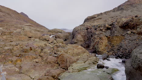 Hermoso-Paisaje-De-Un-Río-Que-Fluye-Cerca-De-Formaciones-Rocosas-En-Islandia---Tiro-Inclinado-Hacia-Arriba
