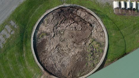 Rising-aerial-of-manure-pit,-slurry-in-round-storage-holding-tank