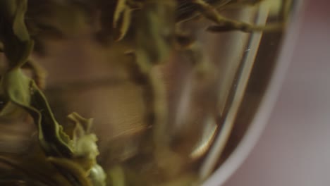 Chinesische-Grüne-Teeblätter,-Die-In-Heißem-Wasser-In-Einer-Traditionellen-Gaiwan-Schale-Aus-Glas-Aufgegossen-Werden