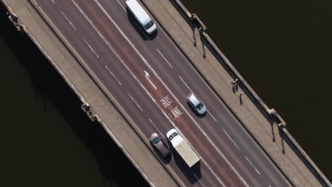 Bus-driving-in-bus-lane-over-Kingston-bridge-in-London,-aerial-ascend-view