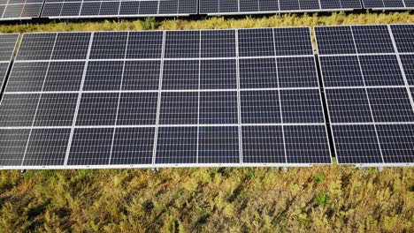 Solar-Panels-In-Green-Field-On-A-Sunny-Day---aerial-sideways
