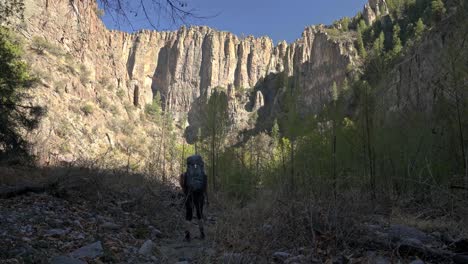 Solo-female-hiking-through-Gila-Wilderness-river-canyon-cliffs,-New-Mexico