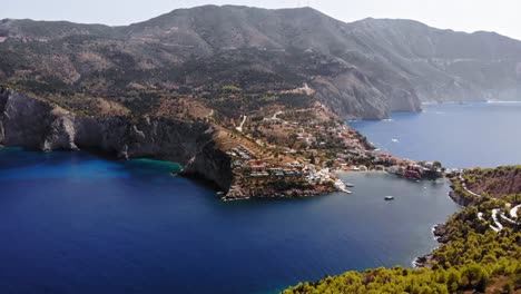 Asos-Village-As-Seen-From-The-Assos-Castle-Peninsula-On-The-Island-Of-Cephalonia,-Greece---aerial-drone-shot