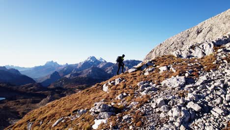 Hiker-hiking-uphill-in-the-Dolomites-in-autumn