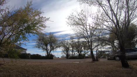 TIMELAPSE---An-empty-road-and-sidewalk-on-a-sunny-day-with-clouds-passing-by-and-trees-around