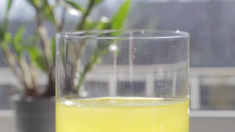 La-Tableta-De-Vitamina-C-Está-Zumbando-Sobre-El-Nivel-De-Agua-De-Bebida-Saludable-Amarilla