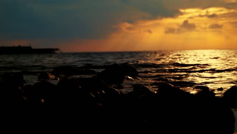 Natur-Dunkle-Goldene-Farbe-Sonnenuntergang-Meerblick-Wasserfluss,-Der-Die-Felsen-Trifft