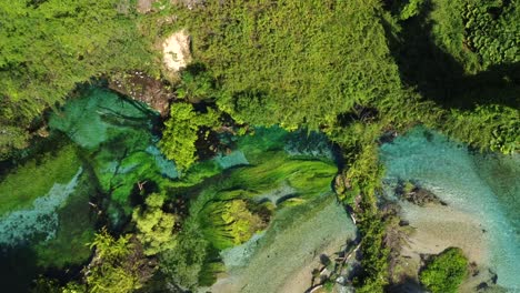 Birds-eye-view-drone-shot-of-the-Blue-Eye-in-Albania---drone-is-ascending,-showing-its-beautiful-color-and-the-clear-water