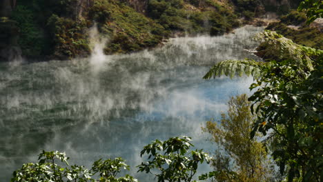 Mystic-toxic-steam-hovering-over-geothermal-lake-during-sunlight-in-New-Zealand---Waimangu-Volcanic-Rift-Valley