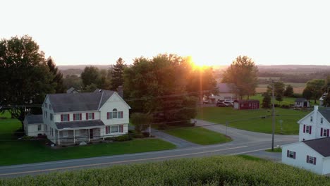 Aerial-establishing-shot-of-two-story-home-in-country-at-sunset,-sunrise