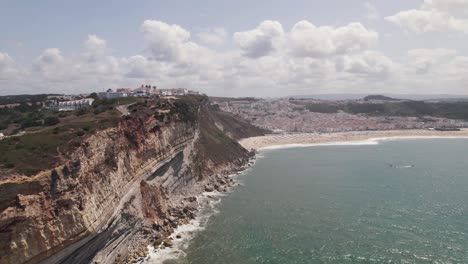 Aerial-panoramic-view-Nazaré-coastline,-village-and-endless-sandy-beach---Portugal