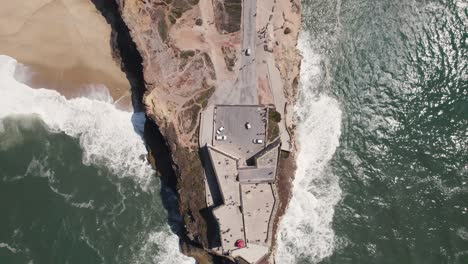 Aerial-top-down-reverse-over-Nazaré-or-Nazare-lighthouse,-Portugal