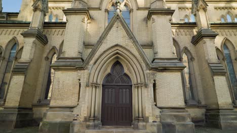 Gothic-Cathedral-Side-Porch-dark-wooden-Entrance-Door-Archway-With-Brick-Buttresses