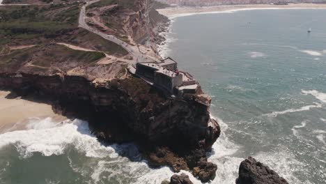 Aerial-Orbiting-over-Famous-LightHouse-on-rocky-Cliff,-Nazaré---Atlantic-Coast