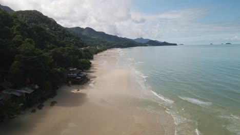 low-angle-aerial-drone-dolly-shot-of-tropical-beach-with-mountain-on-Koh-Chang-Island-in-Thailand