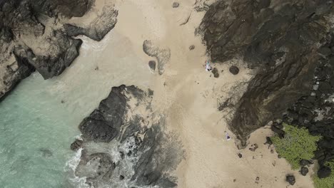 Aerial-overview-of-swimmers-in-a-secluded-beach-cove-tracking-forward